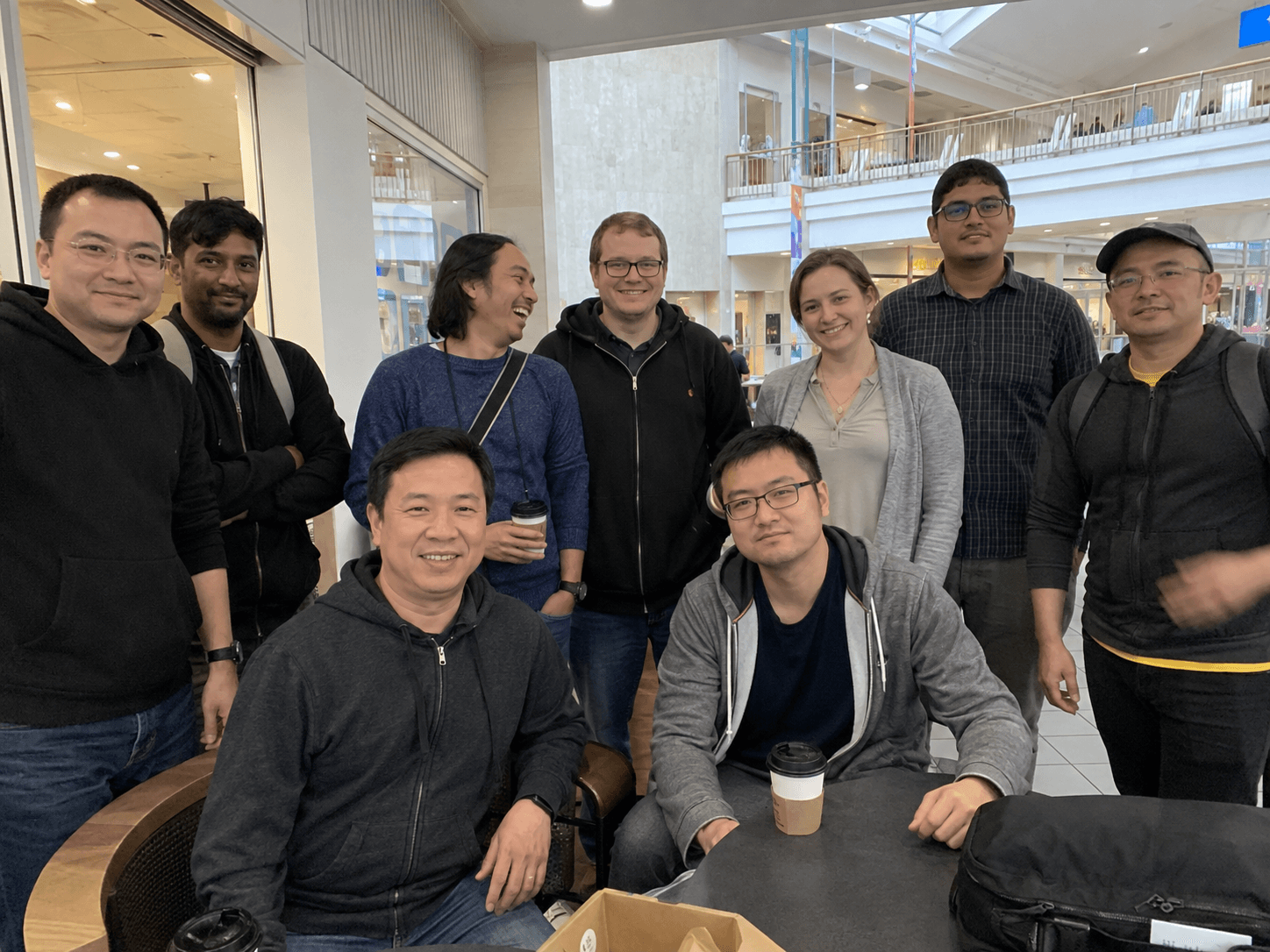 A meetup group posing for a casual photo at a mall cafe.
